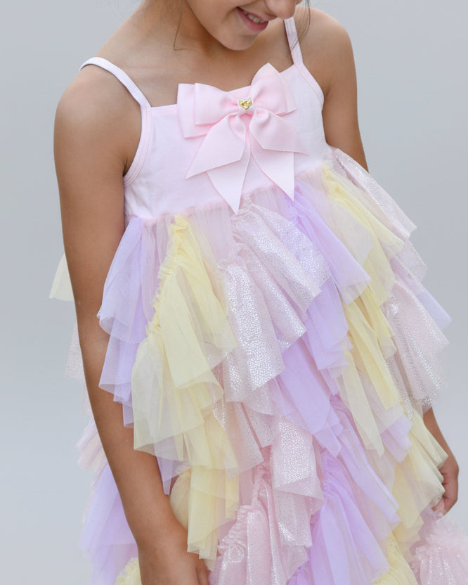 Pastel yellow and pink colored blouse and matching skirt with ruffles worn by a child,