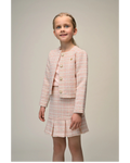 Young girl wearing a 
Le Chic pink tweed suit on a plain background