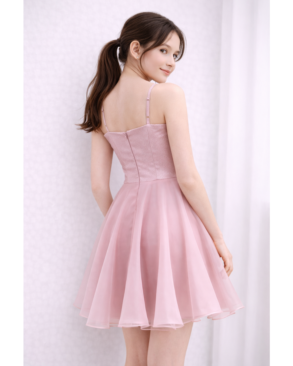 Girl wearing a pink dress against a white background