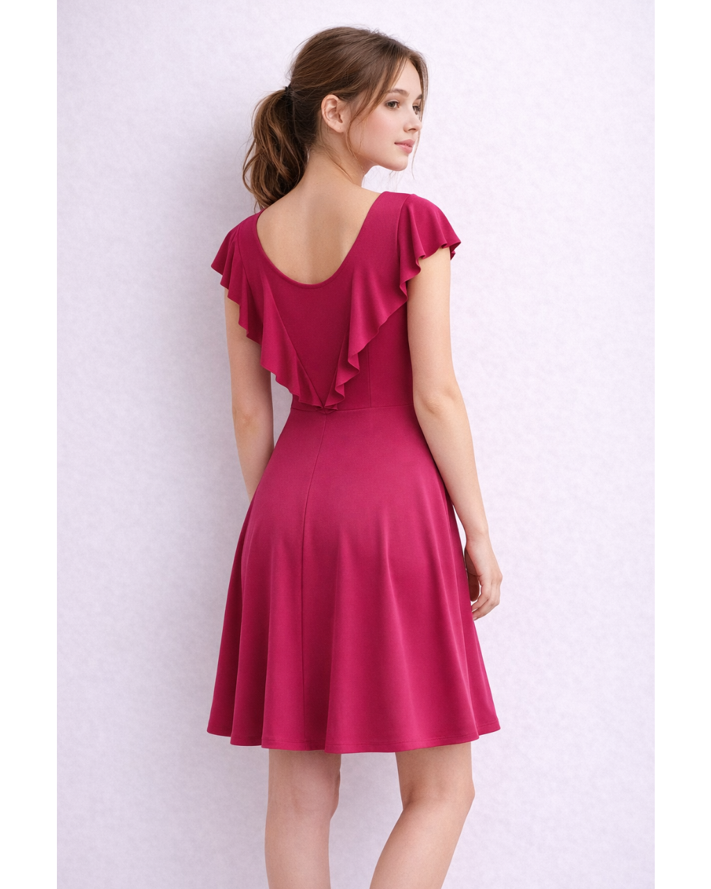 Woman wearing a red dress with ruffled sleeves against a white background